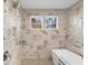 Modern bathroom featuring marble tile, a soaking tub, and natural light from two windows at 145 Canton St, Alpharetta, GA 30009