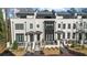 Elegant townhome featuring brick exterior, multiple windows, and manicured landscaping at 145 Canton St, Alpharetta, GA 30009