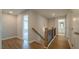 Hallway with wood floors, wood railing, and view into other rooms at 1730 Fulmont Cir, Mableton, GA 30126