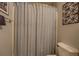 Clean bathroom featuring a white shower curtain with blue stripes and decorative wall art at 6661 Gina Agha Cir, Lithonia, GA 30038