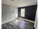 Bedroom features a striking accent wall, big window and gray-washed wood flooring at 673 Pearce Sw St, Atlanta, GA 30310