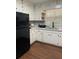 Traditional kitchen with white cabinets, hardwood flooring, and stainless steel refrigerator at 687 N Hairston Rd, Stone Mountain, GA 30083