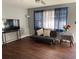 Cozy living room featuring hardwood floors, a ceiling fan, and a stylish futon at 687 N Hairston Rd, Stone Mountain, GA 30083