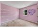 Bedroom with pink walls, diamond-shaped artwork, and a window providing natural light at 881 Brighton Dr, Lawrenceville, GA 30043