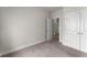 Carpeted bedroom with white trim, featuring a closet and an open doorway, offering ample space at 1286 Brookins Trl, Atlanta, GA 30316