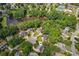 Aerial view of homes in the community surrounding a pond surrounded by mature trees at 2115 Brook Pond Ct, Alpharetta, GA 30005