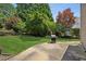 Expansive backyard with a concrete patio area and grill surrounded by lush greenery at 2115 Brook Pond Ct, Alpharetta, GA 30005