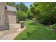 Spacious backyard featuring a well-maintained lawn, trees, and a patio area with a barbecue grill at 2115 Brook Pond Ct, Alpharetta, GA 30005