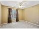 Bright bedroom with tan walls, plush carpet, and a window with decorative curtains at 2115 Brook Pond Ct, Alpharetta, GA 30005