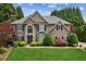 Charming two-story home featuring manicured landscaping, lush lawn, and mature trees at 2115 Brook Pond Ct, Alpharetta, GA 30005