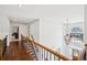Second story hallway with hardwood floors, iron railing, and a view down to the front door at 2115 Brook Pond Ct, Alpharetta, GA 30005