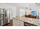 Open concept kitchen with stainless steel appliances and a granite countertop island, leading into the dining area at 2115 Brook Pond Ct, Alpharetta, GA 30005