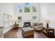 Well-lit living room with a fireplace, vaulted ceilings, large windows, and hardwood floors at 2115 Brook Pond Ct, Alpharetta, GA 30005