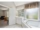 Bathroom with a tub under a window and view into the bedroom at 2115 Brook Pond Ct, Alpharetta, GA 30005