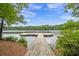 Wooden dock on the lake surrounded by green trees and vegetation at 1102 White Cloud Rdg, Snellville, GA 30078