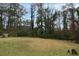 Large backyard featuring a grassy lawn and mature trees at 2630 Colonial Dr, College Park, GA 30337