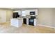 Modern kitchen boasts white cabinets, granite countertops, black appliances, and a convenient center island at 2630 Colonial Dr, College Park, GA 30337