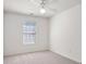 Clean, simple bedroom with a neutral carpet, white trim, and a window providing natural light at 3032 Cedar Glade Ln, Buford, GA 30519
