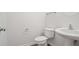 Compact powder room with a pedestal sink, toilet, and modern fixtures for guests' convenience at 3032 Cedar Glade Ln, Buford, GA 30519