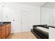 Bathroom with tile floors, dark granite-trimmed tub, wooden vanity, and large mirror at 3071 Lenox Ne Rd # 11, Atlanta, GA 30324