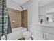 Bright bathroom featuring a shower-tub combo with brown tiling and a white sink vanity at 2136 Garden Pl, Atlanta, GA 30316