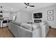 Cozy living room featuring a gray sectional, fireplace, and TV, seamlessly flowing into the kitchen area at 2136 Garden Pl, Atlanta, GA 30316