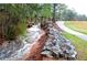 Picturesque creek with stone accents running alongside a paved walking path and lush greenery at 4941 Isle Royal Ct, Stone Mountain, GA 30088