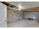 Unfinished basement featuring exposed brick and concrete walls with a single bulb light at 130 Bonnie Ln, Sandy Springs, GA 30328