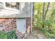 Exterior view of the basement entrance, featuring a white door and brick surround, complemented by natural landscaping at 130 Bonnie Ln, Sandy Springs, GA 30328