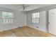 Bright bedroom featuring hardwood floors, two windows with white shutters, and a ceiling fan at 130 Bonnie Ln, Sandy Springs, GA 30328