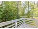 Deck with white railing surrounded by mature trees and lush greenery providing ample privacy at 130 Bonnie Ln, Sandy Springs, GA 30328