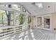 Bright sunroom with white railing, lots of natural light, and an entrance into the home through glass doors at 130 Bonnie Ln, Sandy Springs, GA 30328