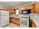 Functional kitchen with wood cabinetry, white appliances, and ample counter space at 2516 Warwick Ne Cir, Atlanta, GA 30345