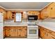 Charming kitchen featuring wood cabinets, white appliances, and tiled backsplash at 2516 Warwick Ne Cir, Atlanta, GA 30345