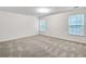Bedroom featuring two windows with blinds, neutral carpet, and white walls for personalization at 3682 Harvest Dr, Decatur, GA 30034