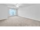 Bright bedroom featuring neutral carpet, a ceiling fan, and a large window providing natural light at 3682 Harvest Dr, Decatur, GA 30034