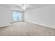Spacious bedroom featuring neutral carpet, a ceiling fan, and a large window allowing ample natural light at 3682 Harvest Dr, Decatur, GA 30034