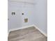 Neutral laundry room with grey wood-look floors and utility connections; wire shelf included for extra storage at 3682 Harvest Dr, Decatur, GA 30034