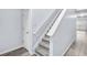 Staircase with white railings leading to the upper level and new, gray laminate floors at 3682 Harvest Dr, Decatur, GA 30034