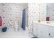 Bright bathroom with floral wallpaper, well-maintained fixtures, and ample storage at 720 First Cotton Dr, Powder Springs, GA 30127