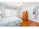 Bright bedroom featuring hardwood floors, a large window with floral valance, and a connecting bathroom at 720 First Cotton Dr, Powder Springs, GA 30127