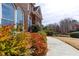 Close-up on the side of a brick house with colorful shrubs and a concrete walkway at 720 First Cotton Dr, Powder Springs, GA 30127