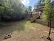 View of the backyard with a wooden staircase and retaining wall, partially covered with sparse grass at 1759 Wilmont Ne Dr, Atlanta, GA 30329