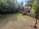 Shot of the backyard featuring a wooden staircase, retaining wall, and some patchy grass at 1759 Wilmont Ne Dr, Atlanta, GA 30329