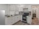 Well-lit kitchen featuring white cabinets, granite countertops, and modern appliances with views to the dining room at 235 Dodd Sw Ave, Atlanta, GA 30315