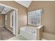 Bright bathroom featuring a soaking tub, decorative window, and neutral paint at 513 Mirramont Pl, Woodstock, GA 30189