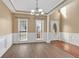 Open dining area with natural light, hardwood floors, white wainscoting, and a decorative chandelier at 513 Mirramont Pl, Woodstock, GA 30189