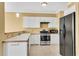 Efficient kitchen features stainless steel appliances, white cabinetry, and tile floors at 513 Mirramont Pl, Woodstock, GA 30189