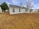 Side view of the house with a neutral toned backyard and a small concrete patio at 2328 Wavetree Nw Ln, Acworth, GA 30101