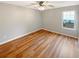 An airy bedroom featuring wood-look floors, a ceiling fan and natural light from the large window at 2328 Wavetree Nw Ln, Acworth, GA 30101